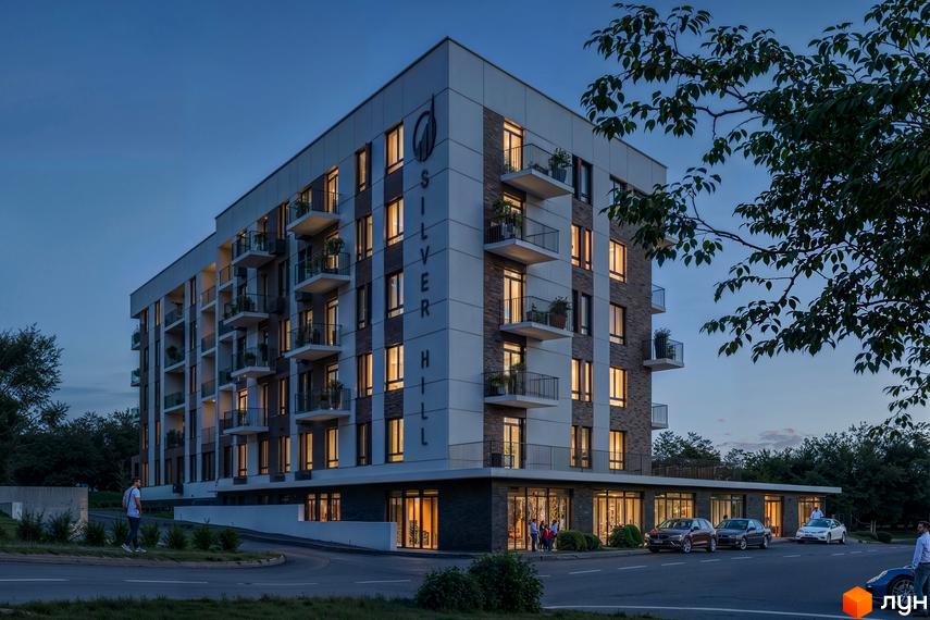 Житловий комплекс Silver Hill: багатоповерховий будинок з комбінованим фасадом, балконами, освітленими вікнами. Навколо дорога, авто, зелень.