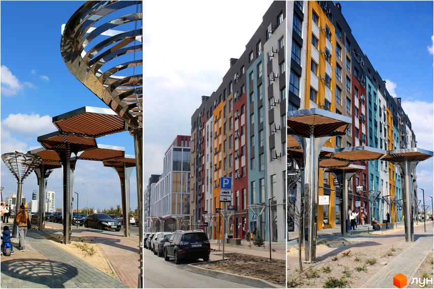 Житловий комплекс На Щасливому: фасади будівель у яскравій кольоровій гамі, сучасна архітектура, доглянута прибудинкова територія з арт-об'єктами та пішохідними зонами.