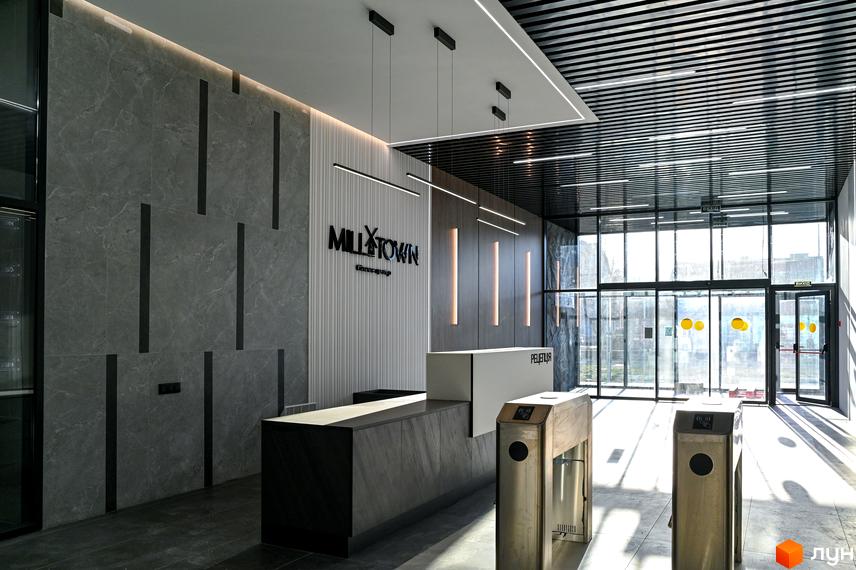 Лобі житлового комплексу Mill Town з рецепцією та турнікетами. Сучасний дизайн інтер'єру з мармуровими стінами та підсвічуванням.