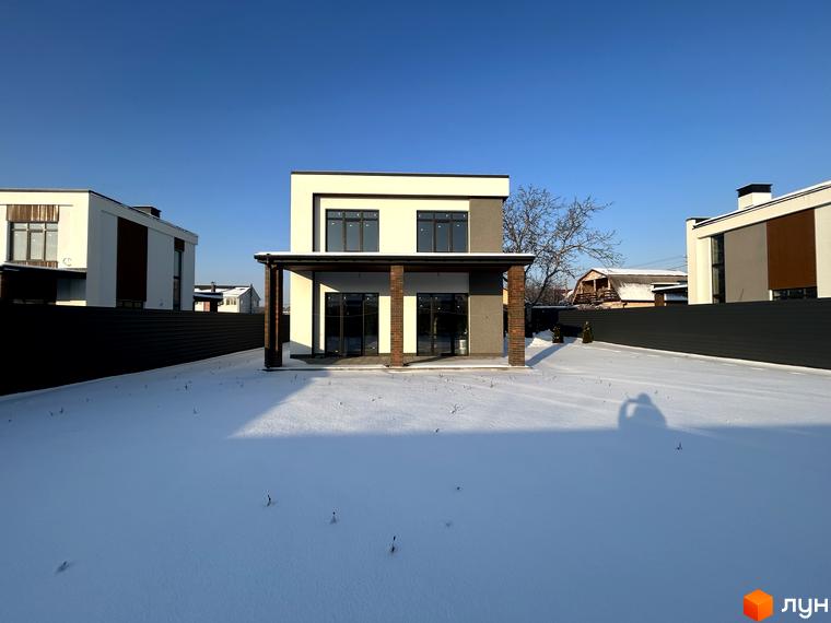 Котеджне містечко Будинки на Франка: двоповерховий будинок з білим та сірим фасадом, критою терасою та засніженою ділянкою.