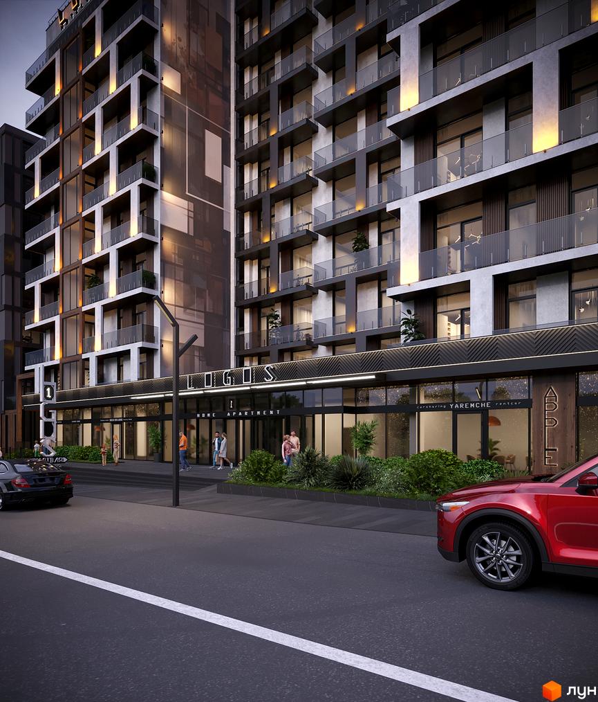 Житловий комплекс Logos Home Apartment з фасадом з бетону та скла, балконами та освітленням. Перед будинком розташована дорога та зелені насадження.