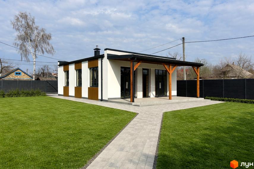 Котеджне містечко КМ Будиночок на Мрії: одноповерховий будинок з навісом та двома вхідними групами, доглянутий газон та доріжка з плитки. Зовнішній вигляд новобудови та прибудинкова територія.