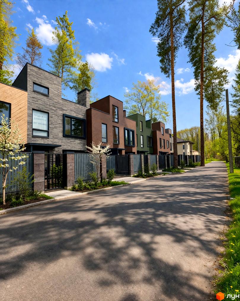 Таунхауси Madera House з цегляним та дерев'яним фасадами, розташовані вздовж асфальтованої дороги з деревами та зеленою травою.
