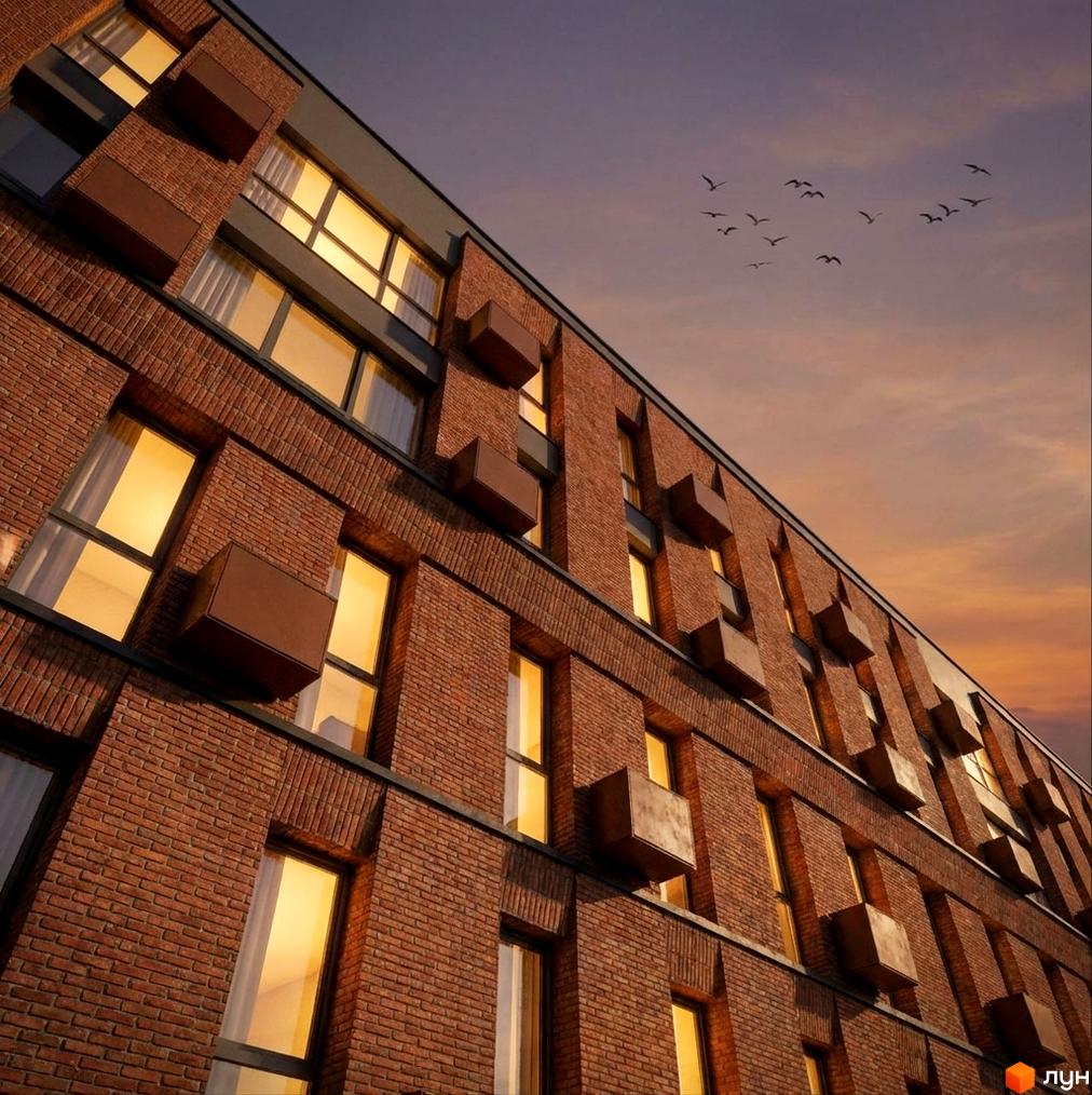 MOVIN hotel: цегляний житловий комплекс з виступаючими елементами та великими вікнами на тлі вечірнього неба з птахами.