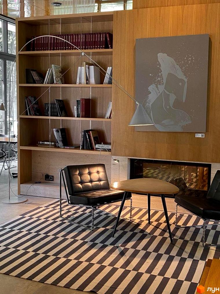 Oselia apartments: сучасний інтер'єр вітальні з книжковою шафою, каміном та зручними меблями. Затишна атмосфера для відпочинку та читання.