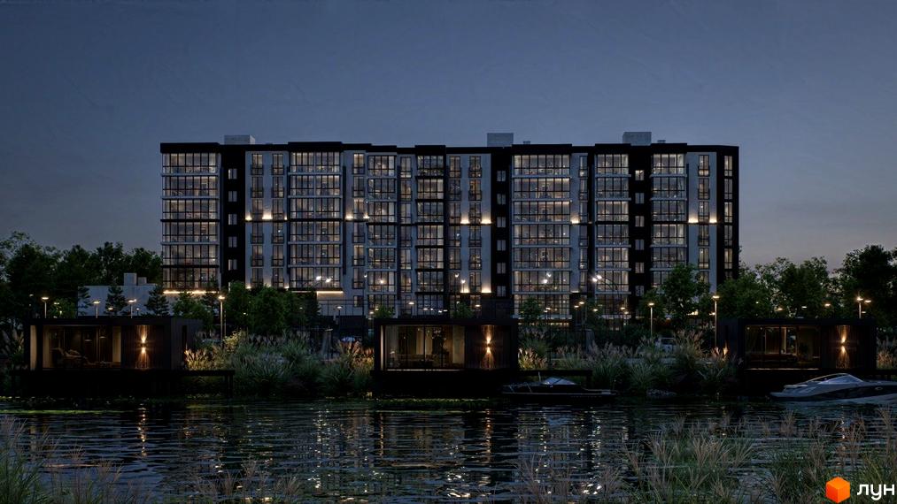 Житловий комплекс ТИSHA вночі з освітленими вікнами, розташований біля водойми з прибережними будівлями та човнами.
