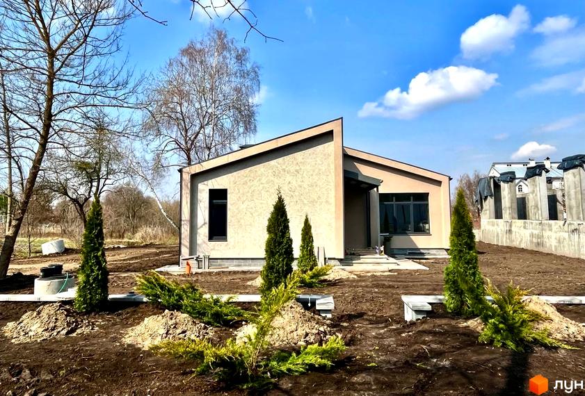 Котеджне містечко КМ TAO Residence: одноповерховий будинок з плоскою покрівлею та прибудинкова територія з молодими деревами та кущами.