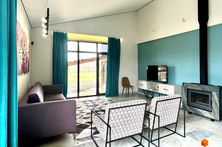 Котеджне містечко TAO Residence: інтер'єр вітальні з панорамними вікнами, каміном та видом на прибудинкову територію.