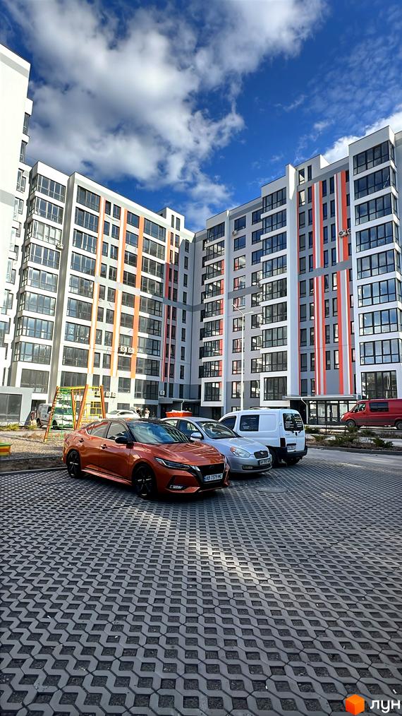 Новобудова на вулиці Привокзальна, 30 з яскравим фасадом та прибудинковою територією з парковкою.