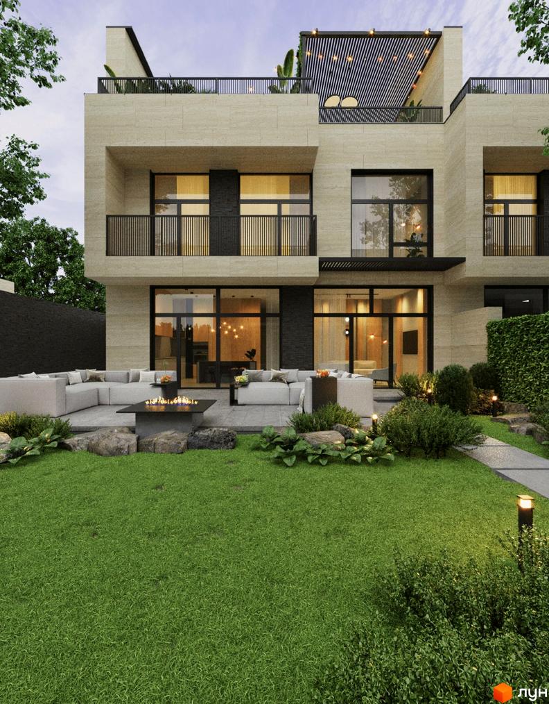 Фасад будинку з великими вікнами та балконами, поруч розташована зона відпочинку з диванами та каміном, зелений газон та кущі.