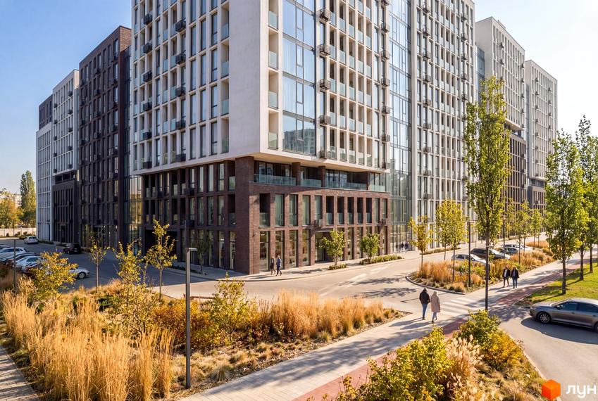 Житловий комплекс Nova City з цегляним цоколем та скляними фасадами, оточений зеленими насадженнями та пішохідними доріжками.