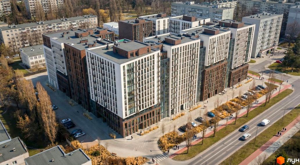 Новобудова Nova City з білими та коричневими фасадами, скляними елементами та прибудинковою територією з деревами та доріжками.