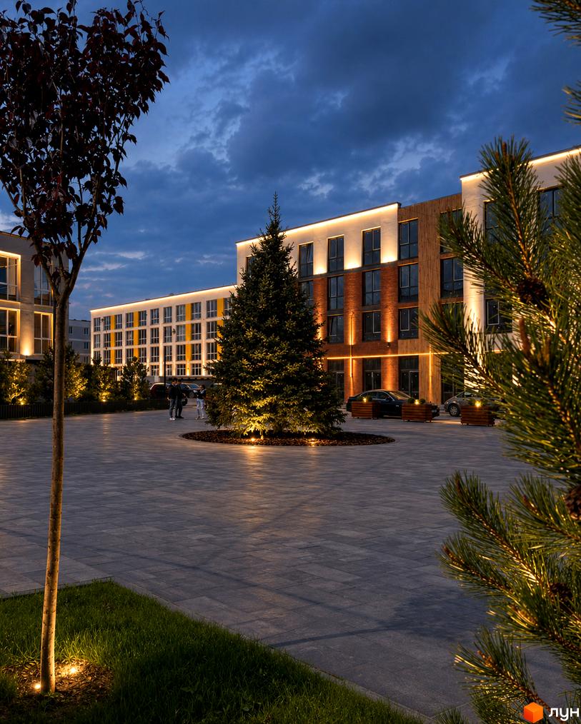 Зовнішній вигляд комплексу Sanville Park з підсвіченими фасадами та прибудинковою територією з ялинкою та деревами.