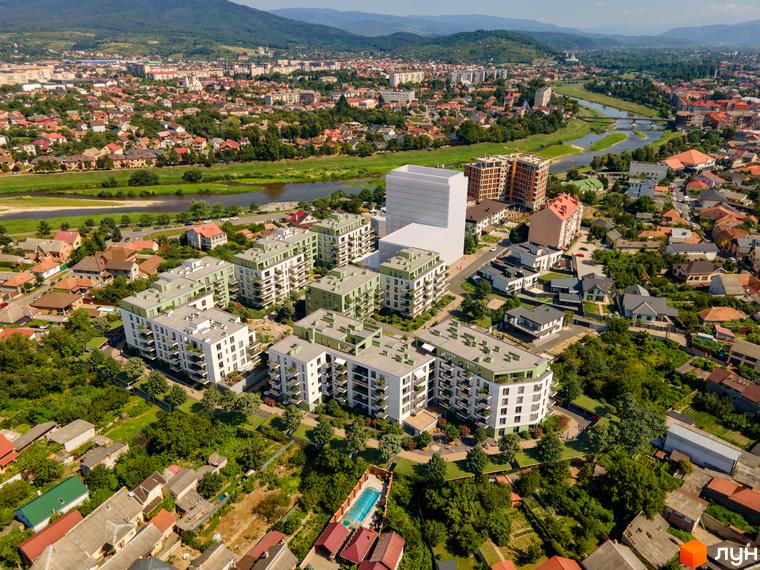 Житловий комплекс Residence City з білими фасадами та зеленими елементами, оточений деревами та з басейном. Вид з висоти пташиного польоту.