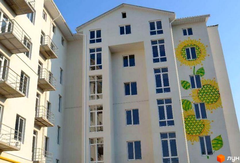 Новобудова на вул. Дизельна, 14 з фасадом, прикрашеним малюнками соняшників. Будинок має багато вікон та балконів.