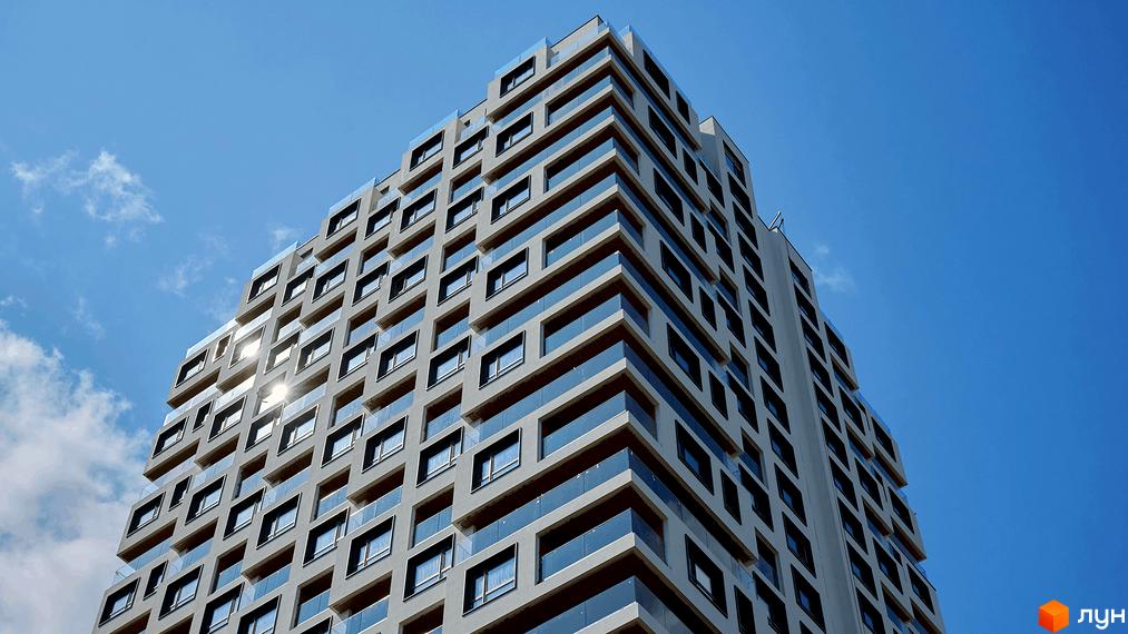 Житловий комплекс Kub29 з багатоповерховим фасадом, що має ступінчасту архітектуру, численні вікна та скляні огородження балконів.