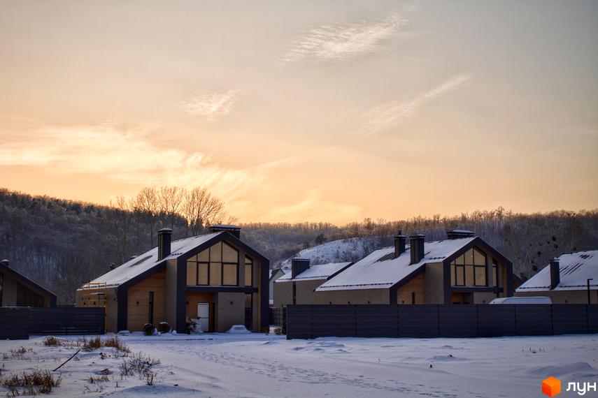 Котеджне містечко КМ Piemont eco village взимку, з сучасними будинками під снігом та огородженою територією.