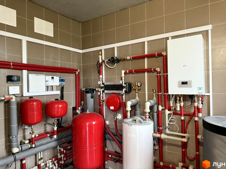 Котеджне містечко Piemont eco village: котельня з бойлером, газовим котлом та розширювальними баками. Система опалення з червоними трубами.