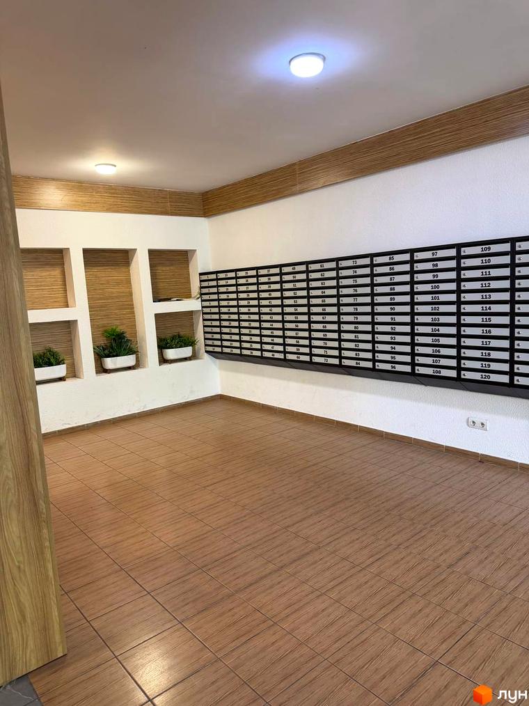 Вхідна група Житлового комплексу Краєвидний з поштовими скриньками, декоративними нішами та плитковою підлогою.