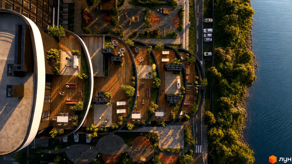 Житловий комплекс SvitLand Residences з вигнутими терасами, що виходять на воду, та зеленою прибудинковою територією.
