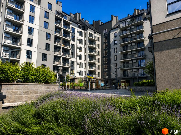 Новобудова Park Residence з балконами та дитячим майданчиком. Зелена прибудинкова територія з квітами та деревами.
