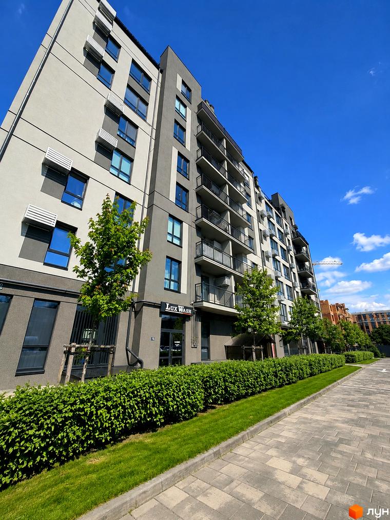 Житловий комплекс Park Residence: багатоповерховий будинок у світло-сірих тонах з балконами та великими вікнами. Озеленена територія з деревами, живоплотом та брукованими доріжками.