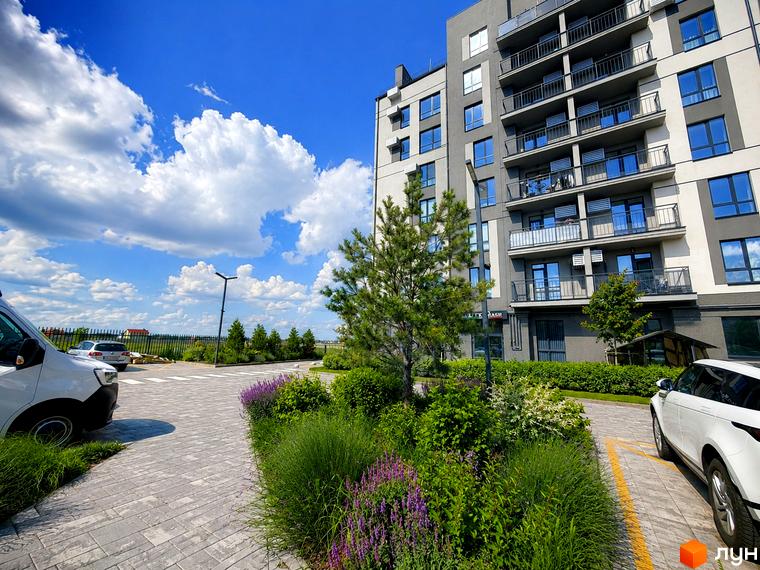 Житловий комплекс Park Residence: багатоповерховий будинок з балконами та великими вікнами, поруч зелена зона з деревами та квітами, парковка.