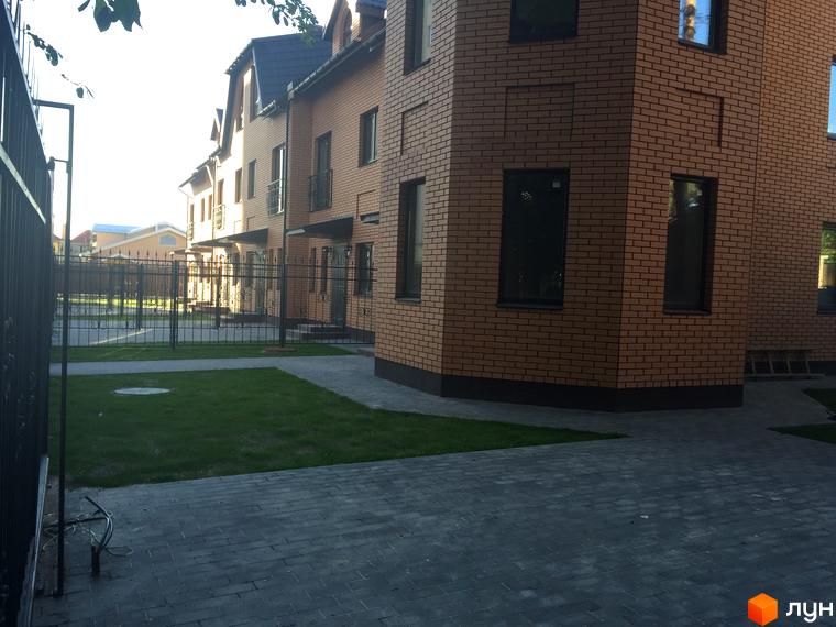 Житловий комплекс Соборна Фортеця: цегляні будинки з темними вікнами, огороджена територія з доглянутим газоном та бруківкою.