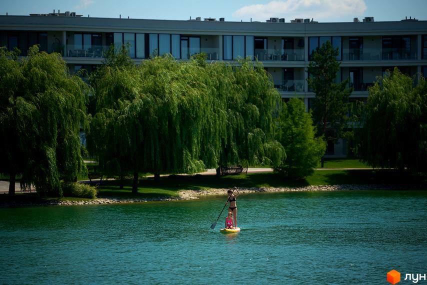 Житловий комплекс Park Lake City з багатоповерховими будинками та зеленою прибудинковою територією біля озера.