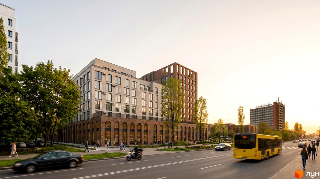 Житловий комплекс Парус WEST з багатоповерховими будівлями, світлими фасадами та цегляними арками на перших поверхах. Поруч дорога, тротуар та дерева.