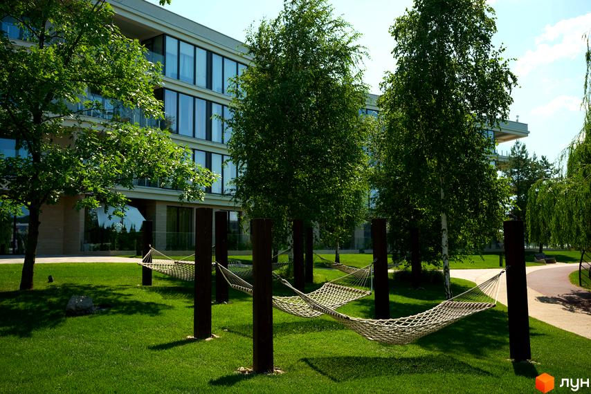 Новобудова Park Lake City з великими вікнами та зеленою прибудинковою територією з гамаками. Відпочинок біля будинку.