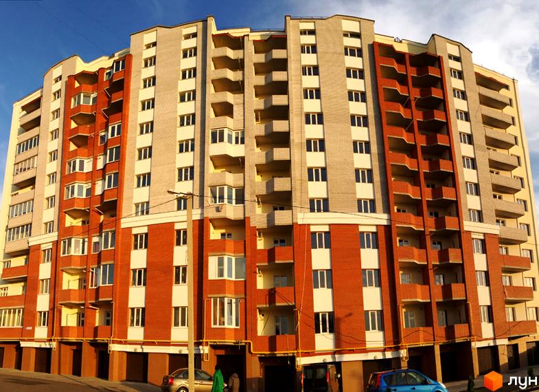 Зовнішній вигляд новобудови ЖК Левада з цегляним фасадом та балконами. Навколо будинку розташовані автомобілі та зелені насадження.