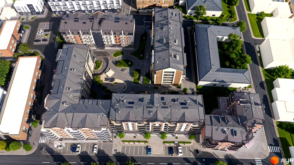 Аерофотографія житлового комплексу на вул. Шухевича, 61. Будинки з сірими дахами та цегляними фасадами, облаштовані зелені двори та парковки.