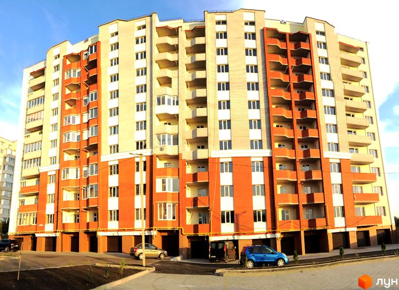 Зовнішній вигляд новобудови ЖК Левада з цегляним фасадом та балконами. Прибудинкова територія з автомобілями та зеленими насадженнями.