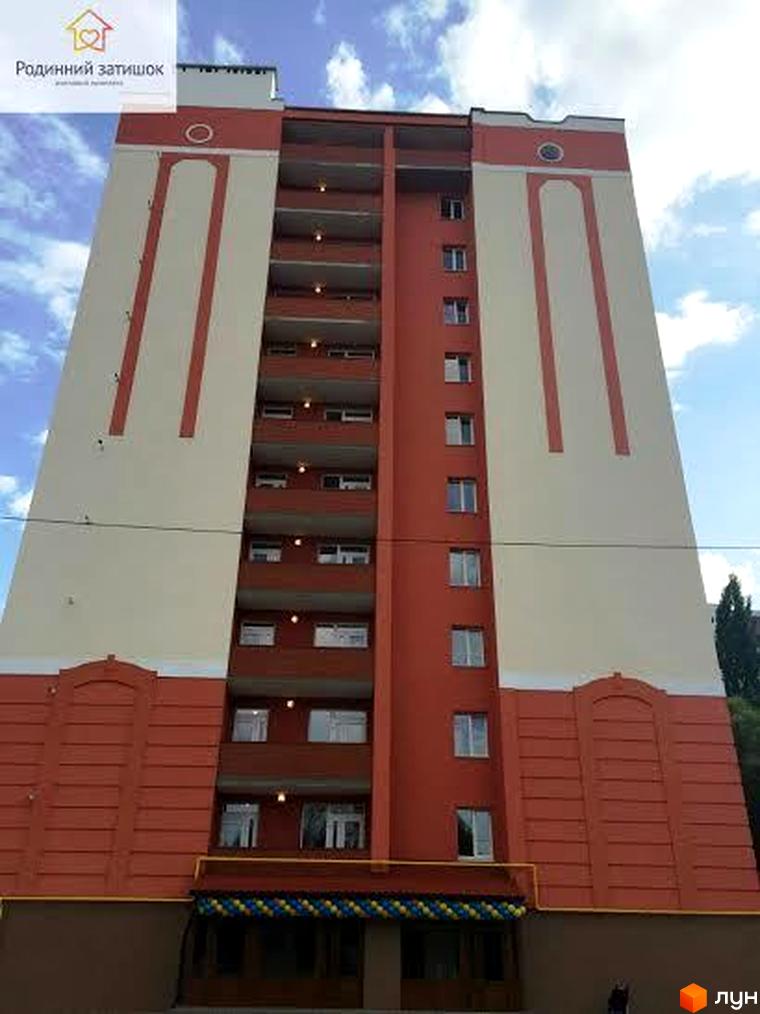 Житловий комплекс Родинний затишок – висотна новобудова з червоно-бежевим фасадом та балконами. Зовнішній вигляд будинку з елементами декору та вікнами.