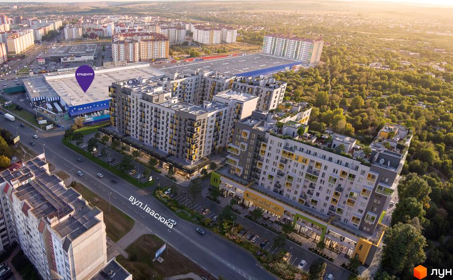 Житловий комплекс SHEPIT – це багатоповерхові будинки з яскравими фасадами та зеленою прибудинковою територією. На фото видно сучасну архітектуру та міський пейзаж.