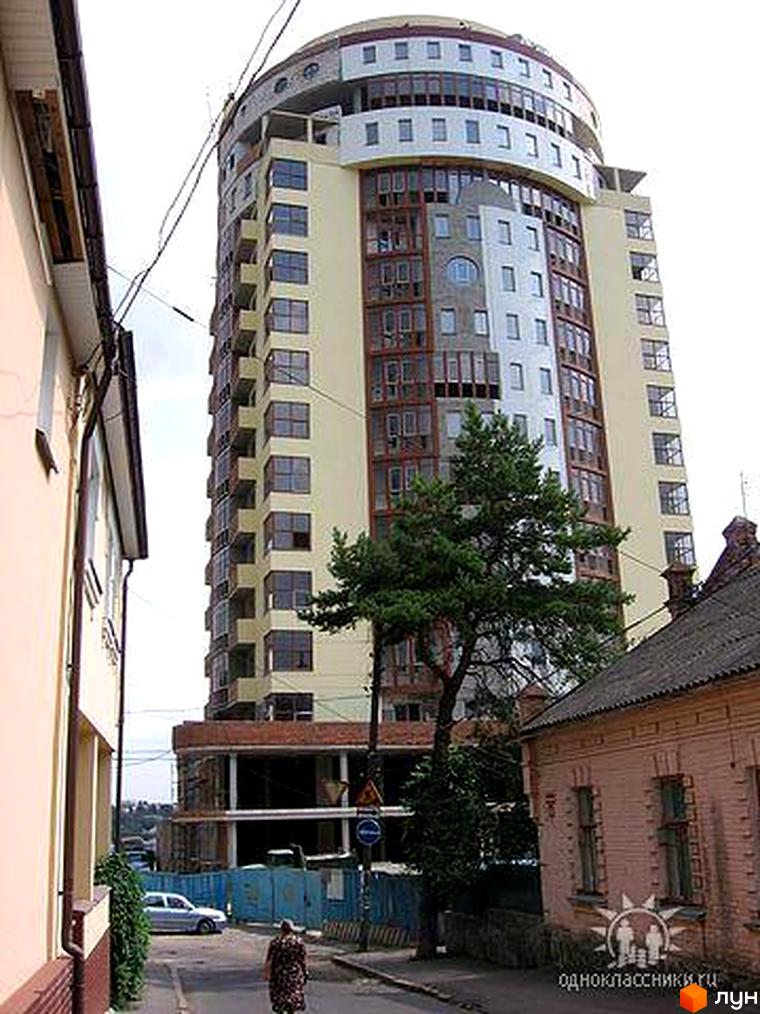 Житловий комплекс на вул. Льва Толстого, 9, з сучасним фасадом та прибудинковою територією, що включає зелені насадження.