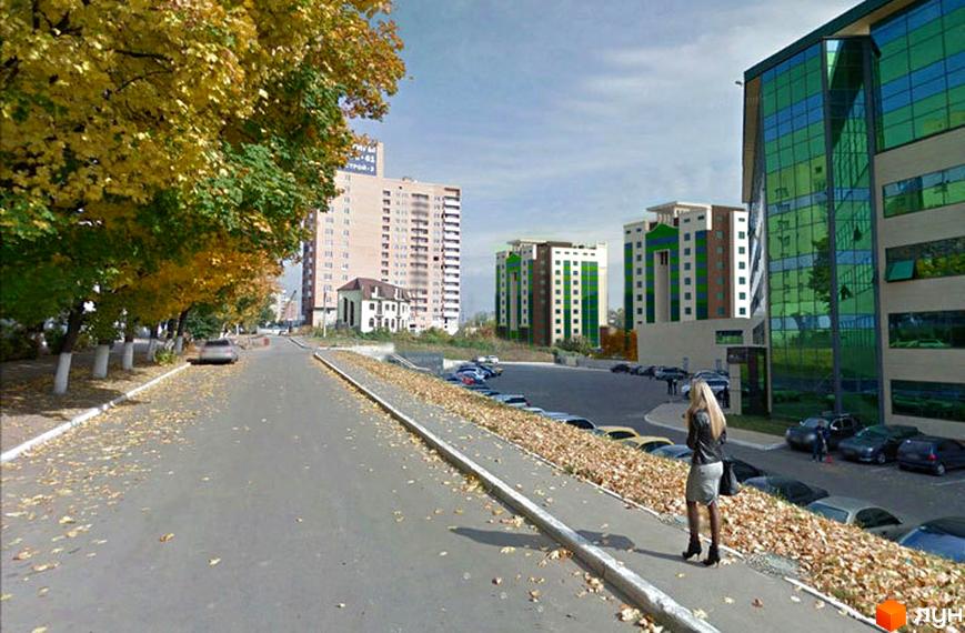 Зображення комплексу Ізумрудне місто з багатоповерховими будинками. Навколо розташована прибудинкова територія з парковкою та деревами.