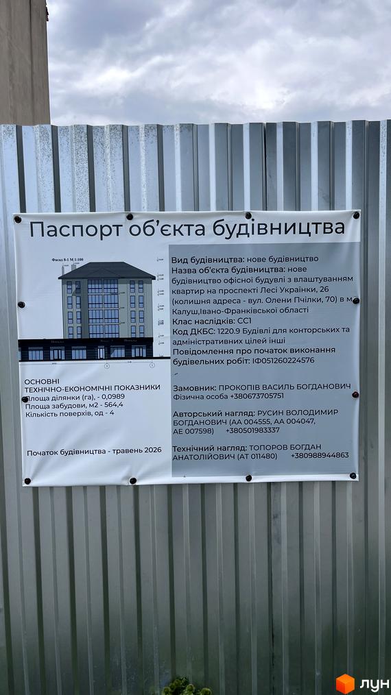 Рендер 4-поверхової будівлі зі світлим фасадом та великими вікнами на просп. Лесі Українки, 26. На передньому плані видно інформаційний стенд будівництва.