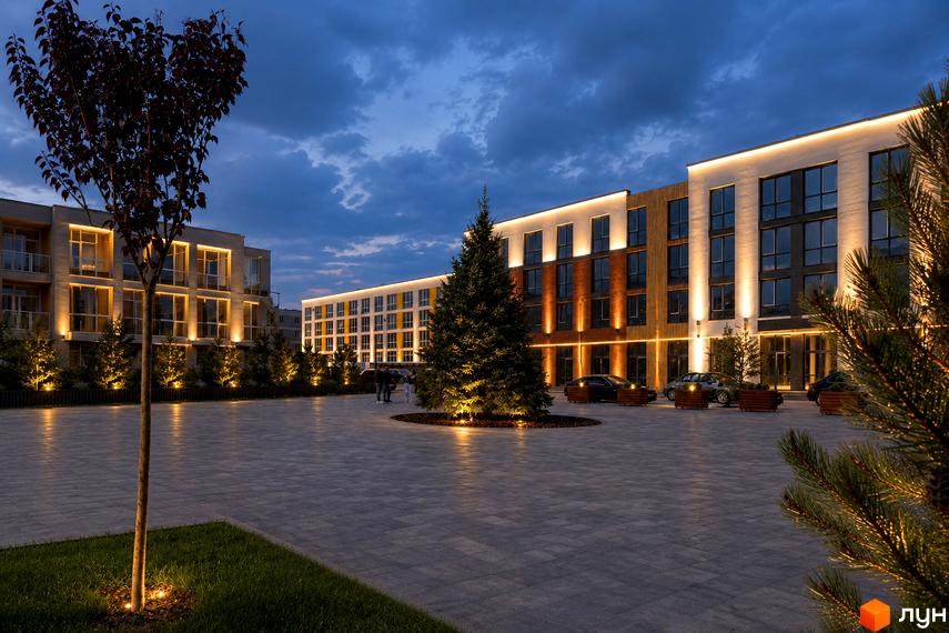 Житловий комплекс Sanville Park: будівлі з різними фасадами та великими вікнами, освітлені ввечері. Двір з бруківкою, зеленню та підсвіченими деревами.