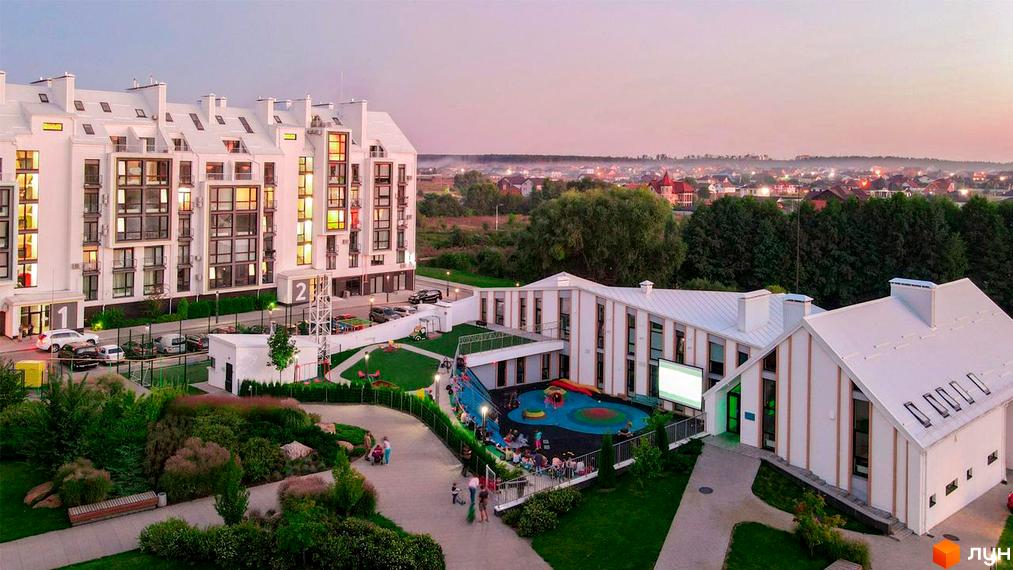 Житловий комплекс City Lake з білими фасадами та численними вікнами, поруч дитячий майданчик та зелена зона. Новобудова з парковкою та благоустроєм території.