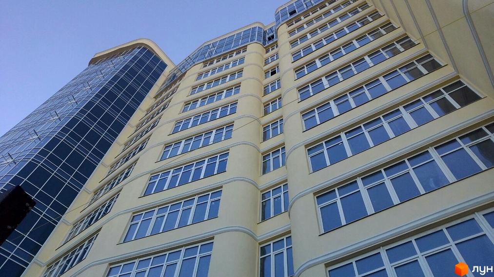 Фасад житлового комплексу Париж, багатоповерховий будинок з панорамними вікнами та скляною частиною будівлі. Зовнішній вигляд новобудови.