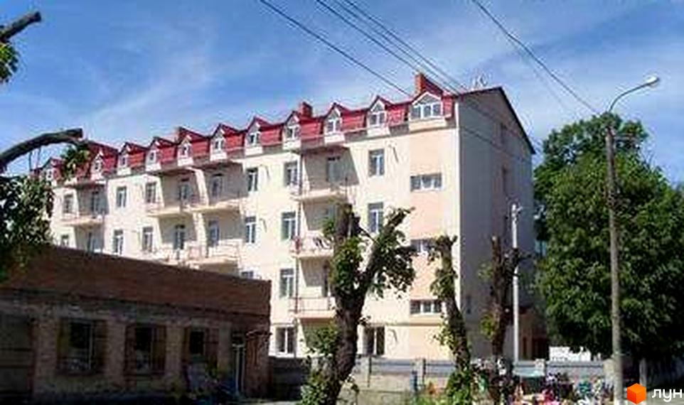 Житловий комплекс на вул. Якова Шепеля, 23б. Будинок з червоним дахом та прибудинковою територією з зеленими насадженнями.