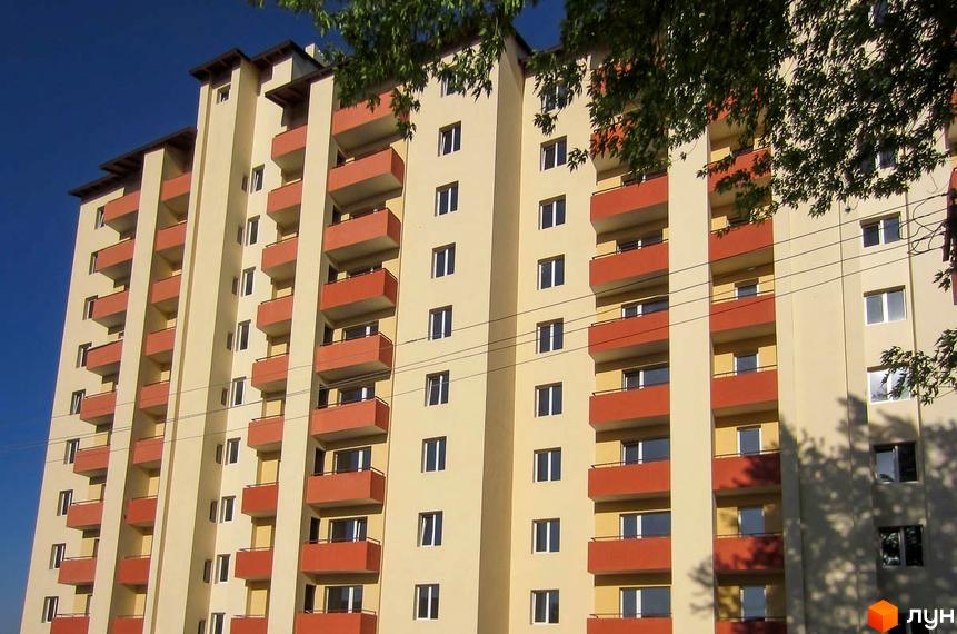 Зображення фасаду житлового будинку по вул. Шевченка, 33. Багатоповерхова будівля з балконами по всій висоті.