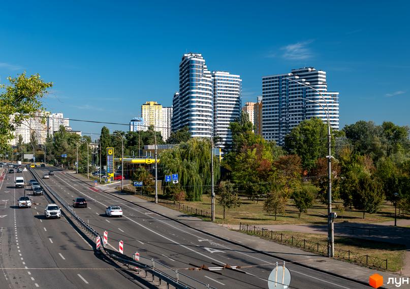 Житловий комплекс Паркові Озера 2 з високими будинками та зеленою прибудинковою територією. Автомобільна дорога та міська інфраструктура.