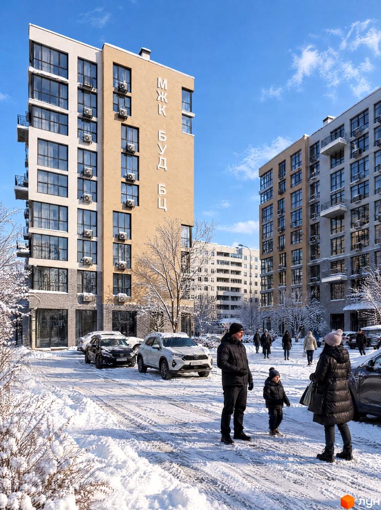 Житловий комплекс TWINS RESIDENCE з панорамними вікнами та кондиціонерами на фасаді біля засніженого двору з припаркованими авто.