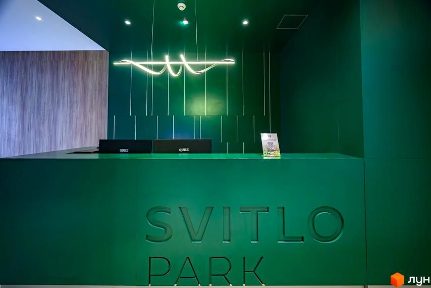 Рецепція новобудови Svitlo Park виконана у насичених зелених тонах з логотипом.