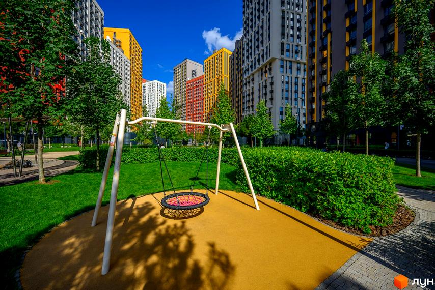 Багатоповерхові будинки біля дитячого майданчика у ЖК Svitlo Park з доглянутою територією.