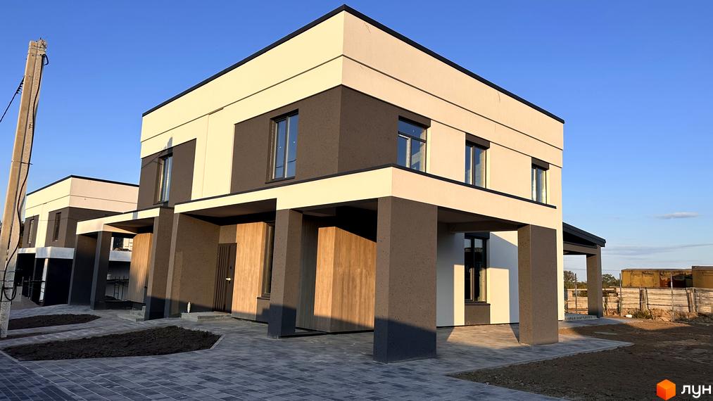 Двоповерховий котедж з панорамними вікнами та навісом біля брукованого подвір'я у КМ Dibrova Park.