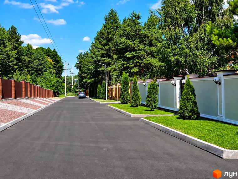 Дорога та зелена прибудинкова територія біля котеджного містечка КМ Swisstown.